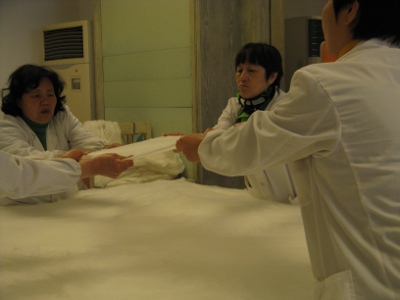 Kiinalaiset valmistavat silkkipeittoa käsityönä.