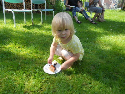 Tässä kuvassa kurssin pienin, Matilda mustikkapiirakkansa kanssa nurmikolla pienellä piknikillä.