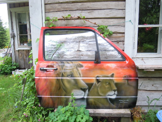 Mikko Loisan auton oveen maalaamat leijonat vartioivat Mänyuperän pihamaata.