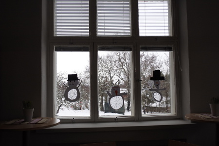 Ekaluokkalaisten lumiukot kurkkivat ikkunoista kevään edistymistä.
