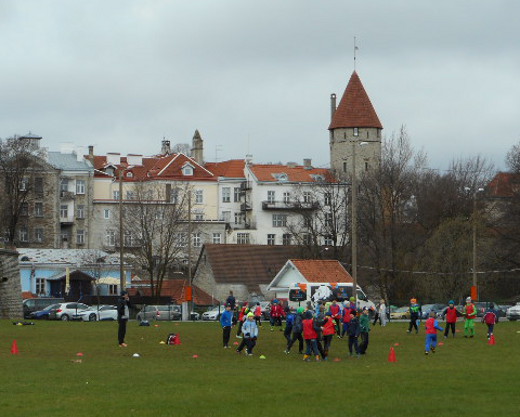 Koululaiset viettivät ulkolilutuntia pelaillen ja palloa potkien kaupungin muurien edessä.
