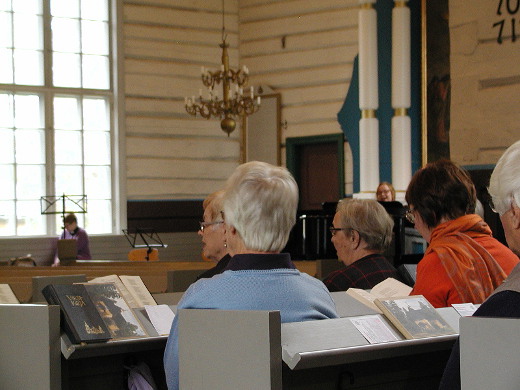 Lemin kirkkokuoro istui alhaalla kirkkosalissa antamassa esimerkkiä. Kanttori Jonna Imeläinen säesti.
