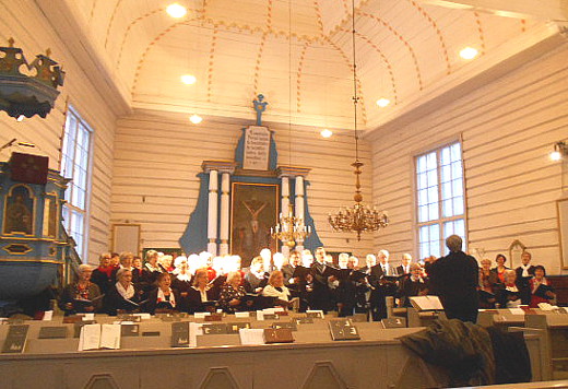 Kolme kirkkokuoroa liitettiin konsertissa suurkuoroksi. Kuvassa se esiintyy Taipalsaaren kanttorin Tea Lavasten johdolla.